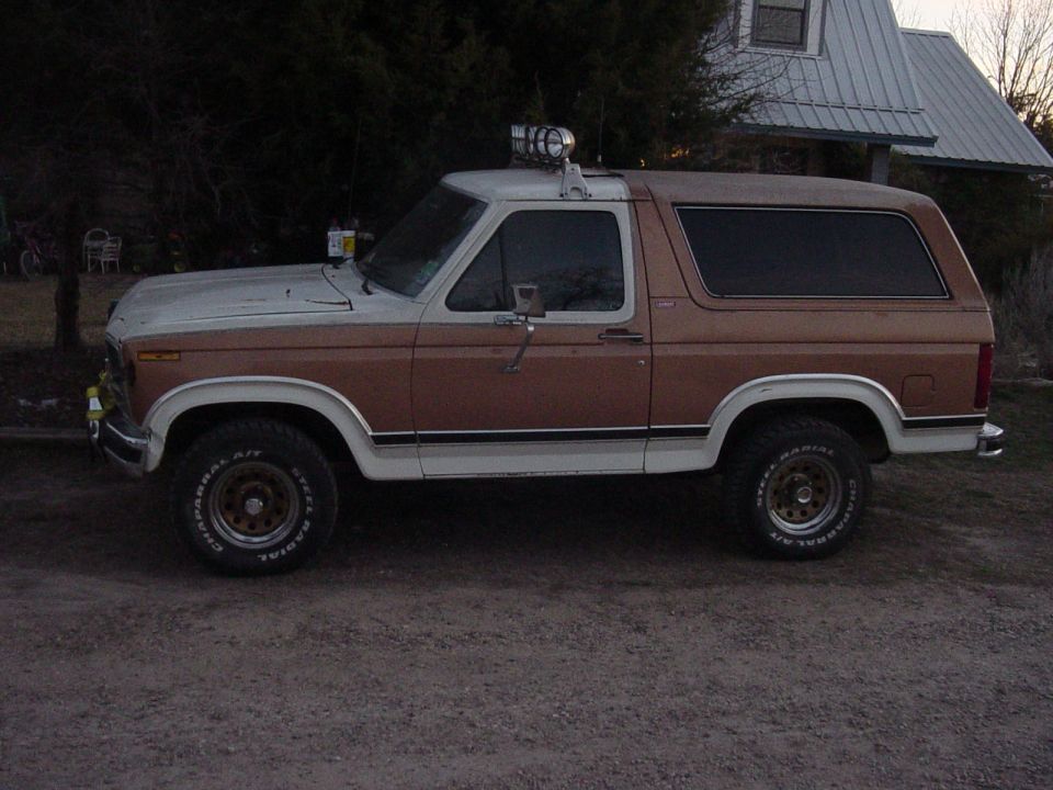 1980s Ford Bronco, brown and white, side view, aftermarket wheels, roof light bar