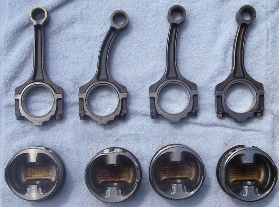 Four connecting rods and four pistons on a blue towel