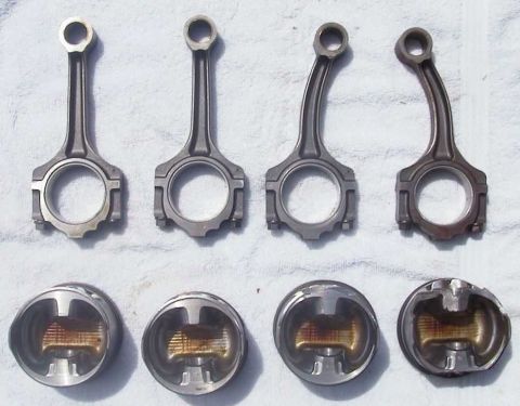 1997 Ford Taurus - Four connecting rods are laid out in two rows, with four pistons shown below them. The connecting rods are arranged in pairs, with two stra…