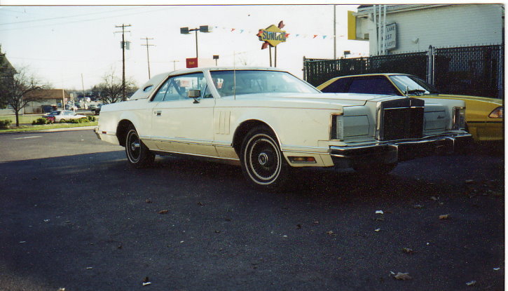 Cream-colored 1977 Lincoln Continental Mark V coupe parked on asphalt, front quarter view