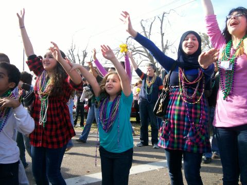 1993 Ford Bronco - People celebrate outdoors, many wearing colorful beads and raising their arms.
