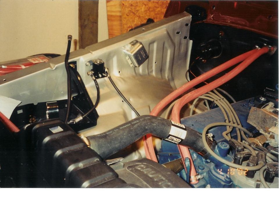 Engine bay with hoses and wiring visible. Some text on a hose reads 'GCR'