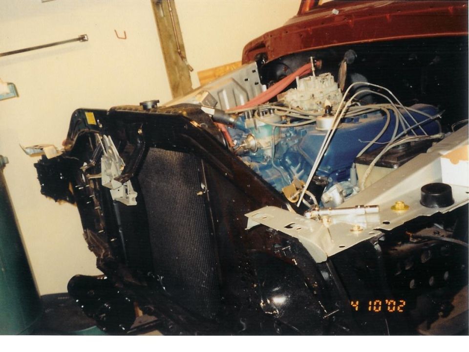 Vehicle engine bay with blue engine block, carburetor, and radiator. Date stamp '4 10 02'