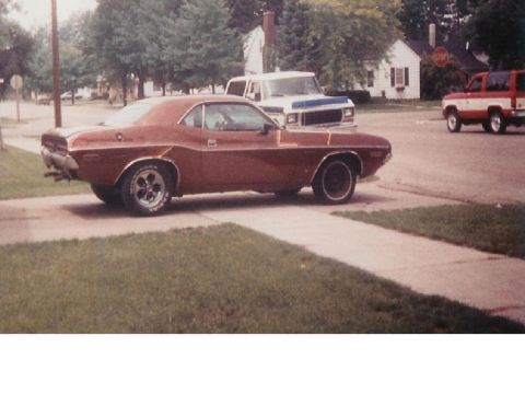 1978 Ford Bronco - A brown 1970 Dodge Challenger is parked on the side of the road with other vehicles in the background.