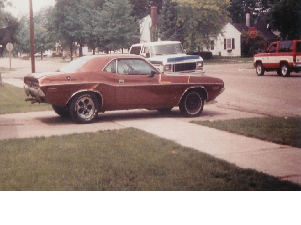 Brown 1970 Dodge Challenger side view with chrome trim and aftermarket wheels