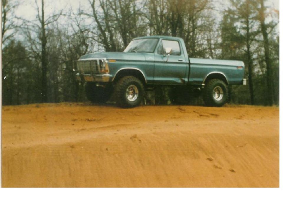 Teal pickup truck on a dirt hill
