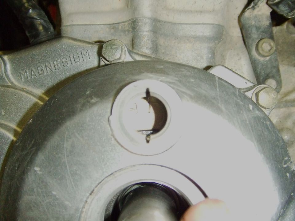 Timing inspection window on a magnesium engine cover with rotor marks visible