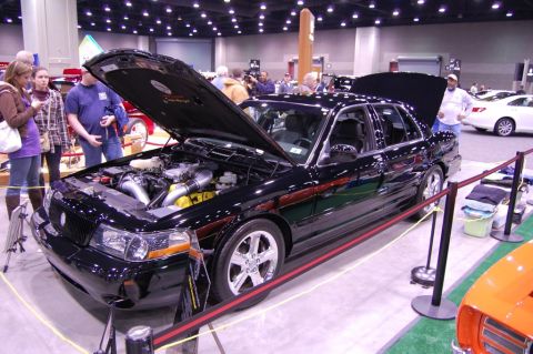 2003 Mercury Marauder - A black 2003 Mercury Marauder is displayed with its hood open, revealing a modified engine at a car show.