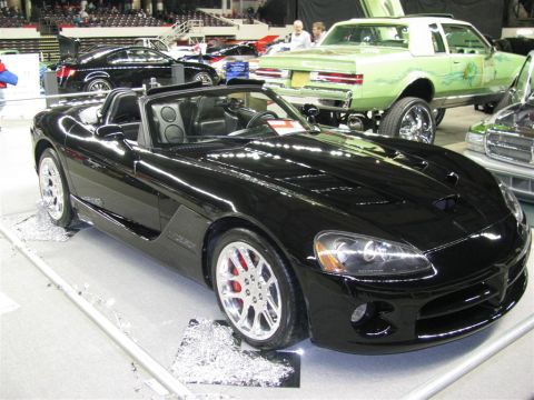 2003 Mercury Marauder - A black convertible sports car is displayed indoors with other vehicles in the background.