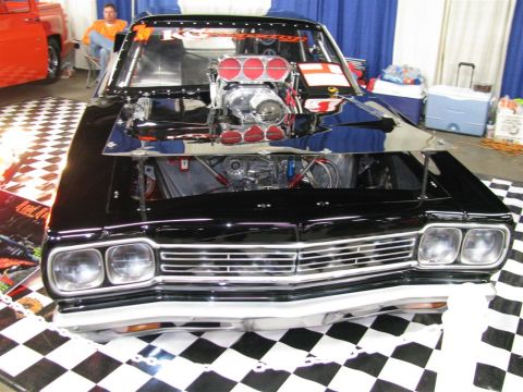 2003 Mercury Marauder - A heavily modified black car with a prominent supercharger is displayed indoors on a checkered floor.