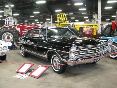 2003 Mercury Marauder - A black 1967 Ford Galaxie 500 is displayed indoors with other vehicles and machinery in the background.