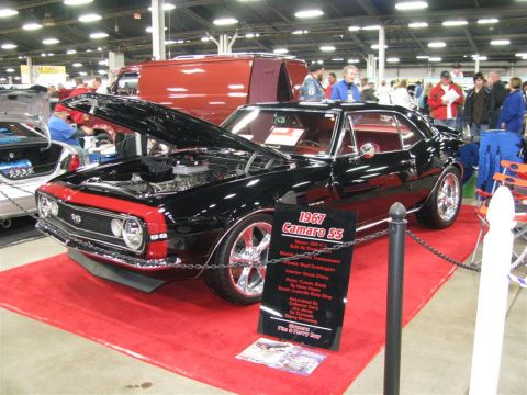 2003 Mercury Marauder - A classic 1967 Camaro SS is displayed with its hood open at a car show.