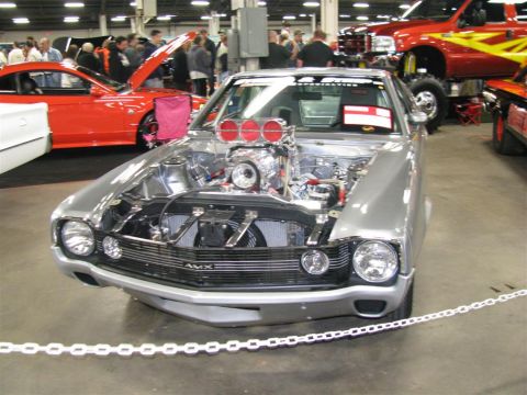 2003 Mercury Marauder - A highly customized silver car with its hood open, revealing a powerful engine with multiple carburetors, displayed at a car show.
