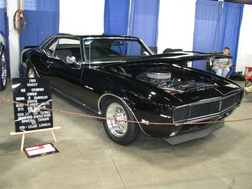 Black 1968 Chevrolet Camaro RS with hood open, showing engine