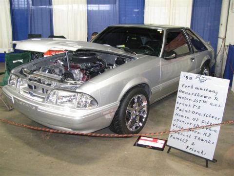 2003 Mercury Marauder - Silver Ford Mustang with hood open, displaying its engine and a sign with vehicle details.