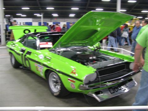 2003 Mercury Marauder - A lime green 1970 Dodge Challenger, modified for racing, is displayed with its hood and trunk open at a car show.