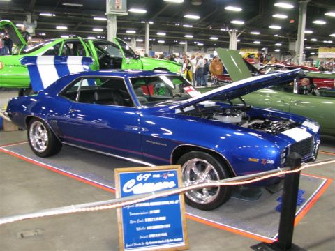 2003 Mercury Marauder - A blue 1969 Chevrolet Camaro Z/28 is displayed with its hood open, alongside other vehicles at a car show.