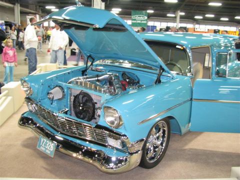 2003 Mercury Marauder - A light blue 1956 Chevrolet Bel Air custom car is displayed with its hood and door open at a car show.
