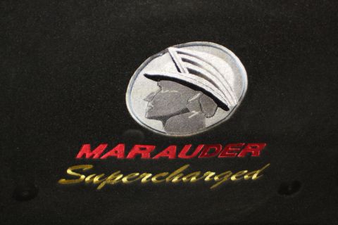 2003 Mercury Marauder - Emblem reads "MARAUDER Supercharged" with a Mercury logo on a black surface.