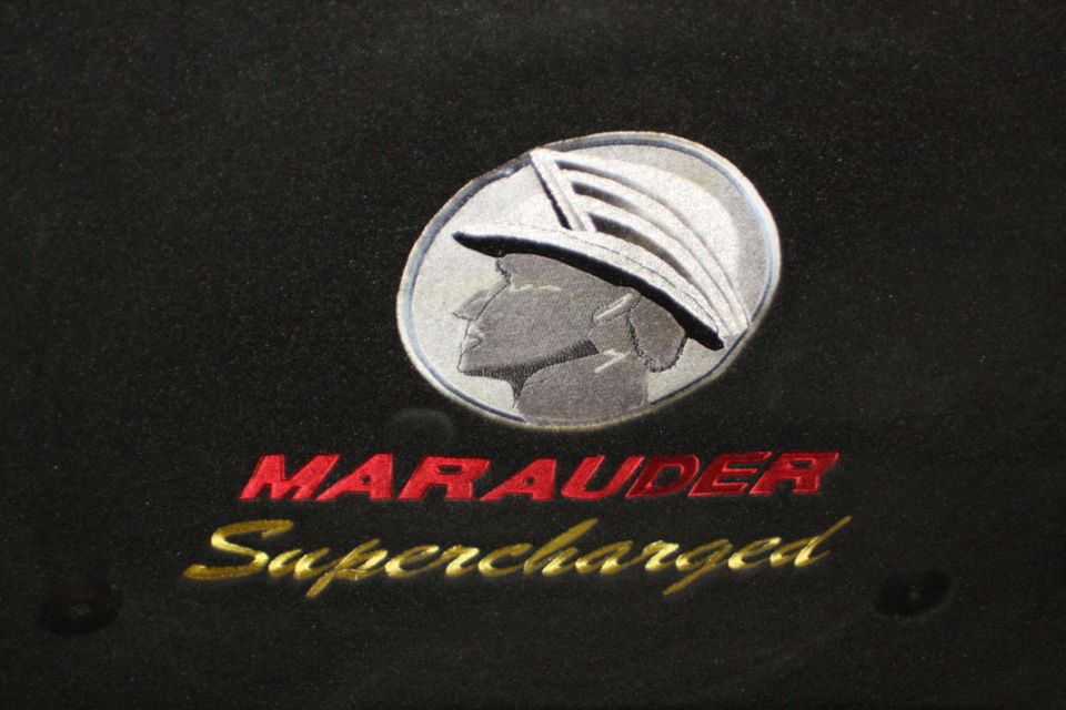 Black background with a silver Mercury emblem and red "MARAUDER" text above gold "Supercharged" text