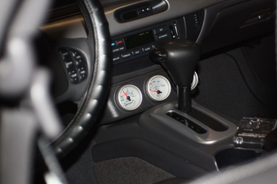 Interior view of a car with aftermarket gauges and a gear shifter