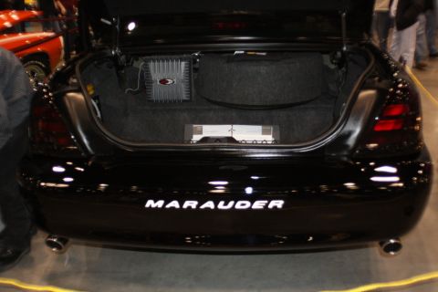 2003 Mercury Marauder - The trunk of a black 2003 Mercury Marauder is open, revealing aftermarket amplifiers and the spare tire well.