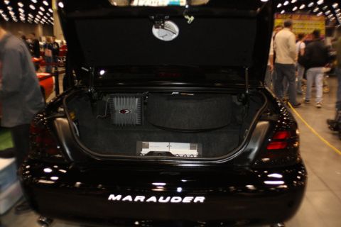 2003 Mercury Marauder - The trunk of a black sedan is open, revealing audio equipment and the 'Marauder' nameplate.