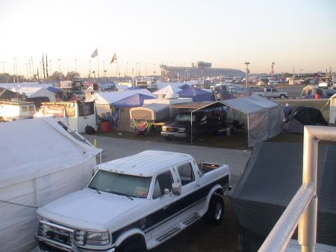 1993 Ford C-350 (Centurion Conversions) - A white Ford F-Series pickup truck is parked in a campsite with tents and other vehicles visible.