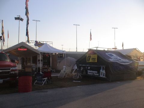 1993 Ford C-350 (Centurion Conversions) - Tents and a red truck are set up at a race track, likely for an event like the Daytona 500.
