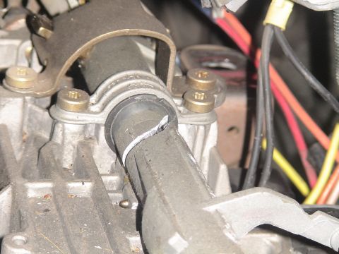 1993 Ford C-350 (Centurion Conversions) - Close-up view of a cracked steering column housing, showing internal wiring and mounting hardware.