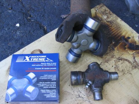 1986 Ford Bronco - A new Rockford Xtreme U-Joint is shown next to a used one, with part of a driveshaft visible.