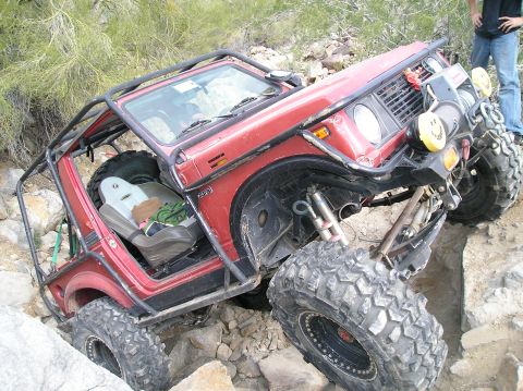 1986 Toyota Hilux - This heavily modified off-road vehicle navigates a challenging rocky terrain.