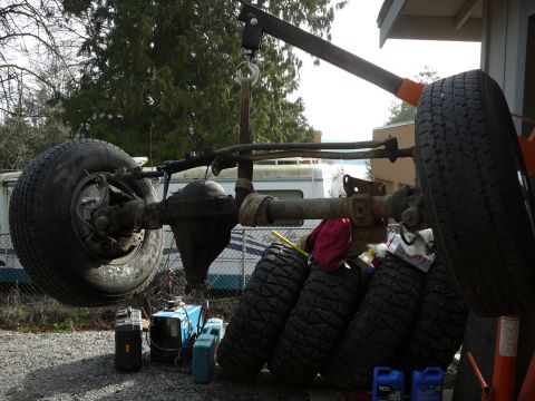 1991 Ford Bronco - Axle assembly and spare tires are staged for work, with a welder and fluids visible.