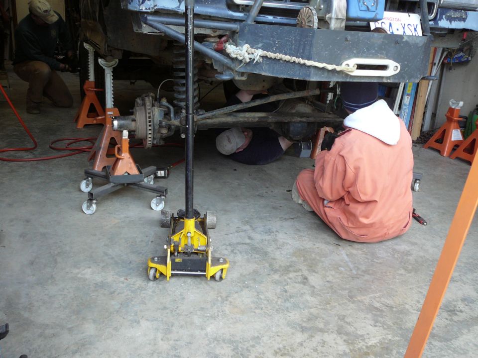 Mechanics working under a lifted vehicle with a winch on the front bumper