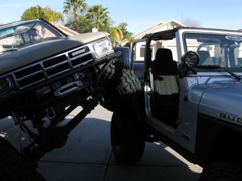 1986 Toyota Hilux - Two modified trucks are parked close together, one angled towards the other.
