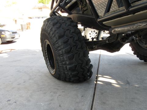 1986 Toyota Hilux - A close-up view of a large off-road tire and suspension system on a truck.