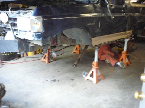 1991 Ford Bronco - A black 1991 Ford Bronco is shown on jack stands, with its front end elevated for maintenance.