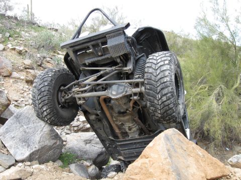 1986 Toyota Hilux - Off-road vehicle stuck on rocks on a desert trail.