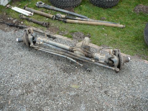 1991 Ford Bronco - A disassembled front axle assembly, likely for an older 4x4 vehicle, is laid out on the ground.