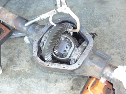 1991 Ford Bronco - Open differential housing with gears and a C-clamp. Part number 1026D is visible on the housing.