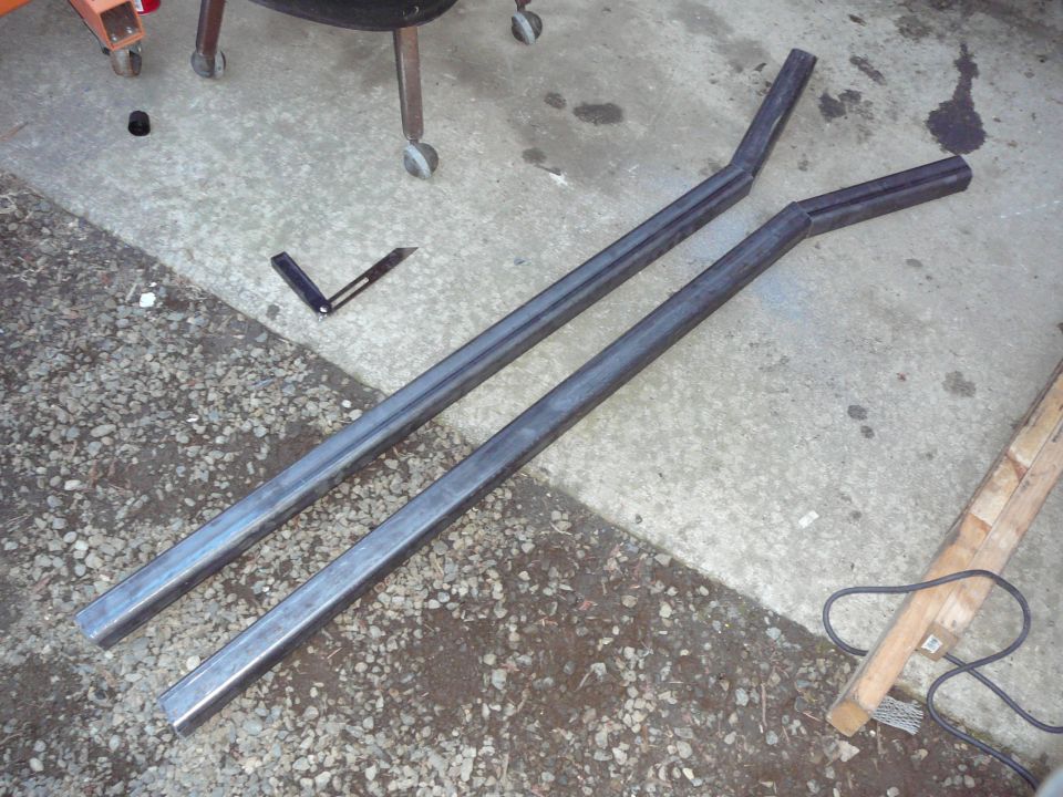 Two bent metal tubes on concrete floor