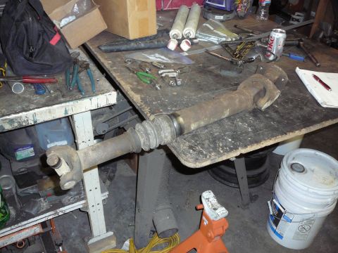 1991 Ford Bronco - Workbench cluttered with tools and a driveshaft assembly, possibly for a 1-ton swap project.