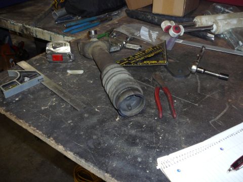 1991 Ford Bronco - A workbench is cluttered with tools and a driveshaft component, suggesting repair or modification work.