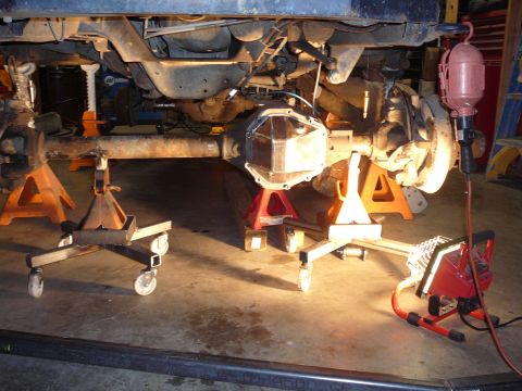 1991 Ford Bronco - Vehicle's undercarriage is elevated on jack stands, with a focus on the differential cover and suspension components.