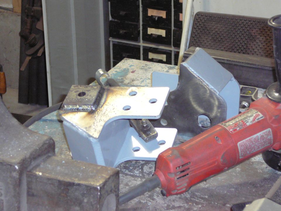 Welded metal brackets and angle grinder on workbench