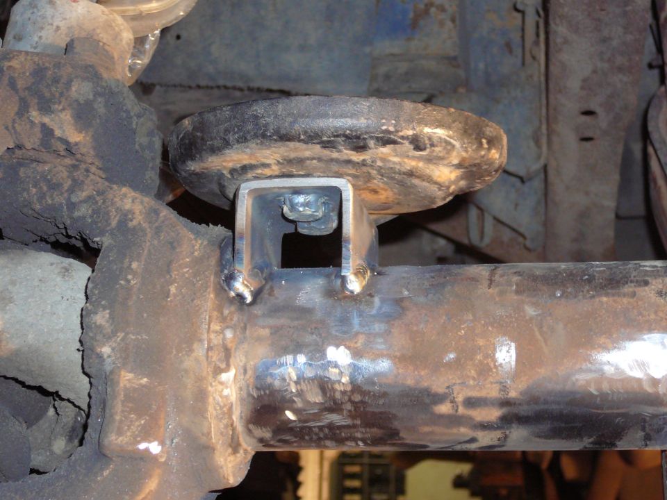 Close-up of a custom welded bracket attached to a vehicle's axle tube