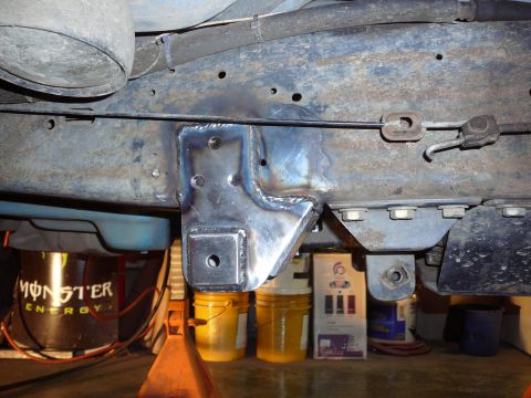 1991 Ford Bronco - A custom-welded bracket is attached to the vehicle's frame, with various buckets and a Monster Energy can visible underneath.