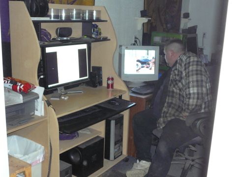 1991 Ford Bronco - A man sits at a computer, viewing an image of a blue off-road vehicle on his monitor.