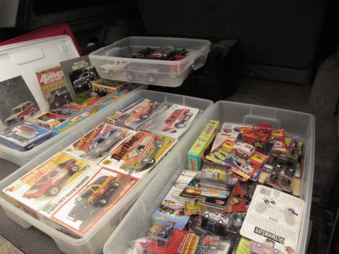 1986 Ford Bronco - A collection of diecast model vehicles and their original packaging is organized in plastic bins.