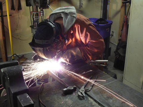 1991 Ford Bronco - Welding sparks fly as a person works on metal in a workshop setting.